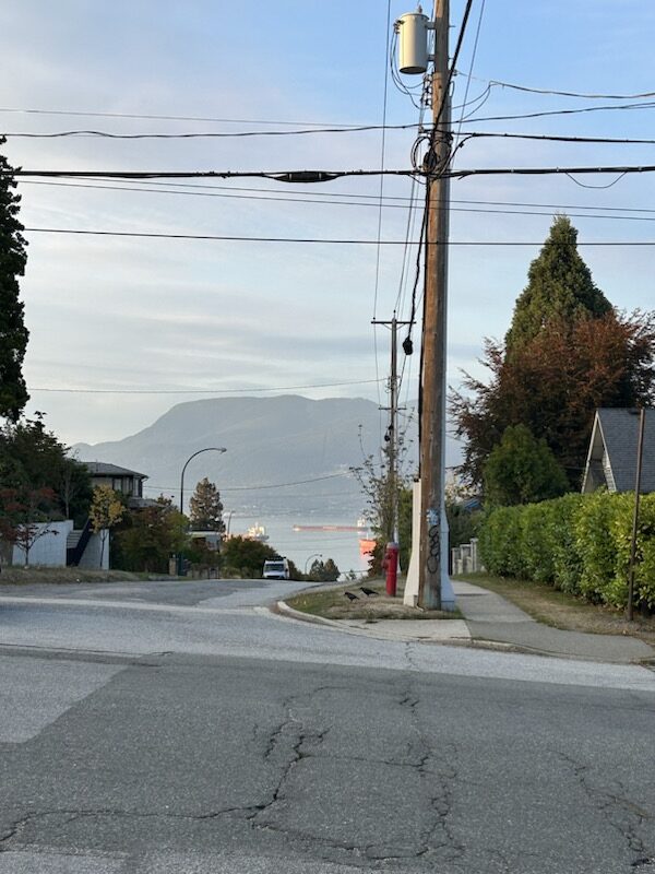 The view of mountains and the ocean taken from the street.