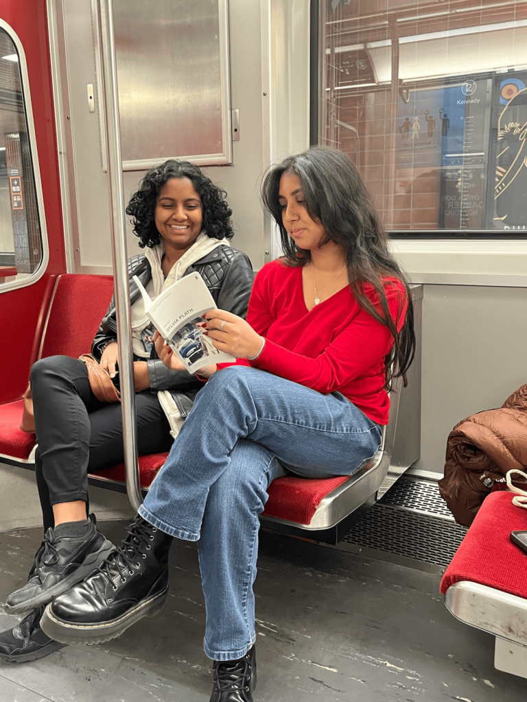 Praevalli and her girl best friend reading on the train together.